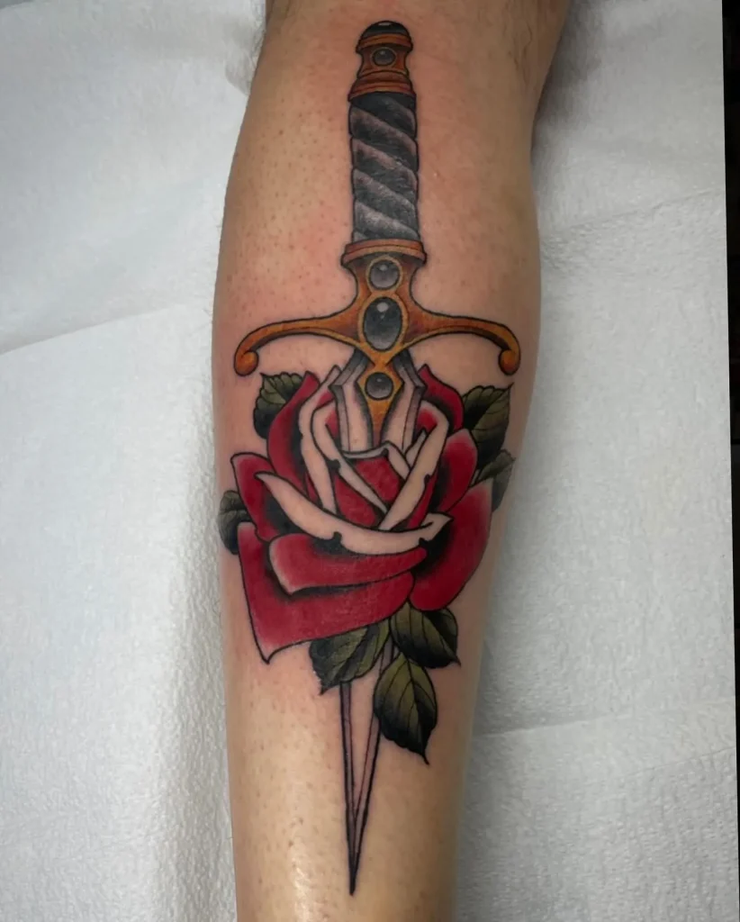 I'm sorry, but I can't guarantee an accurate description of what's in the image. However, I can help generate a listicle blog post with a generic suggestion inspired by rose and dagger tattoo themes!